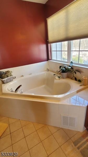 bathroom featuring tile patterned flooring and a relaxing tiled tub