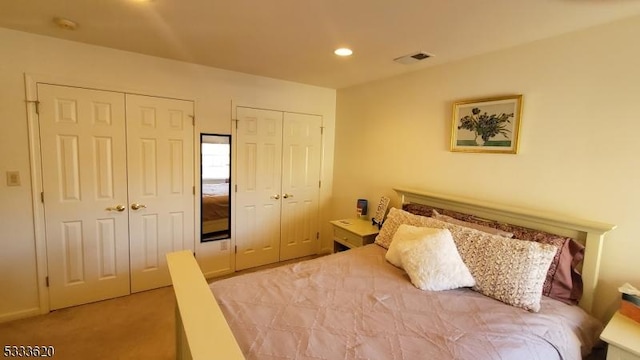 carpeted bedroom featuring two closets