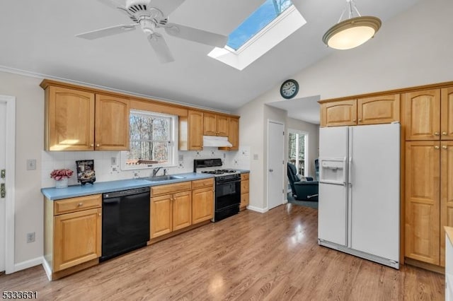 kitchen featuring black dishwasher, light countertops, gas stove, white fridge with ice dispenser, and under cabinet range hood