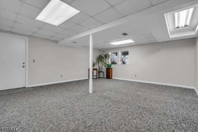 basement featuring carpet, a drop ceiling, and baseboards