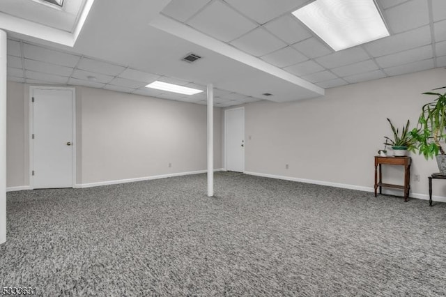 finished below grade area featuring carpet floors, a paneled ceiling, visible vents, and baseboards