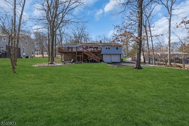 view of yard with aphalt driveway, a deck, an attached garage, and stairs