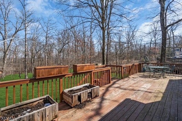 deck with a yard and outdoor dining area