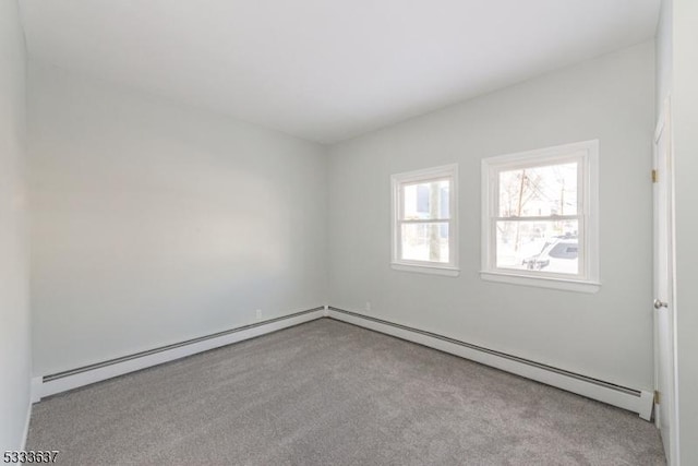 carpeted empty room with a baseboard radiator