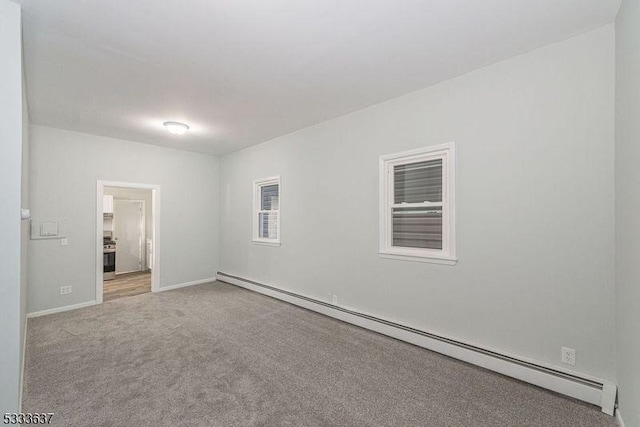 empty room featuring a baseboard radiator and light carpet