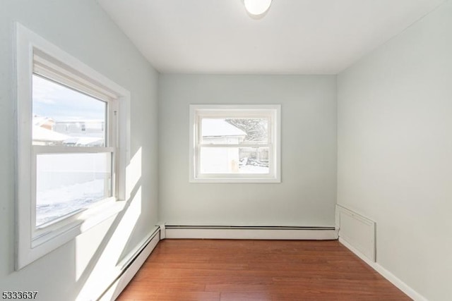 unfurnished room with light wood-type flooring and baseboard heating