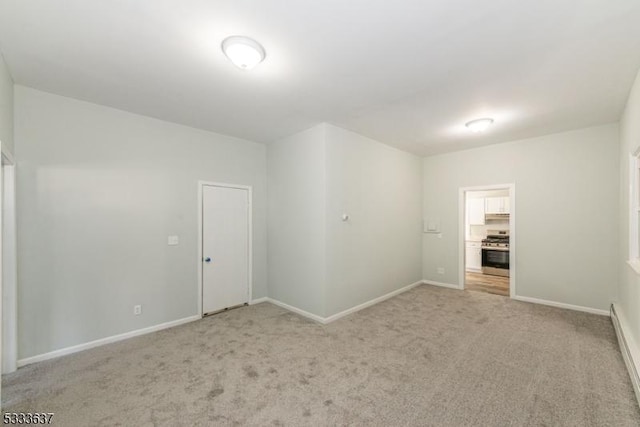 empty room featuring light carpet and a baseboard radiator