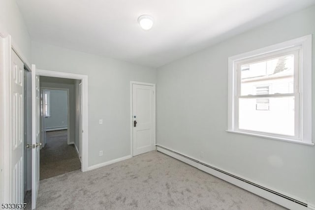 carpeted empty room with a baseboard radiator