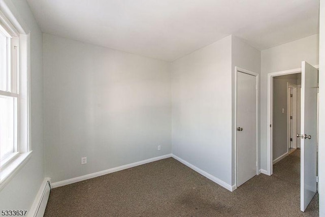 unfurnished room featuring carpet and baseboard heating