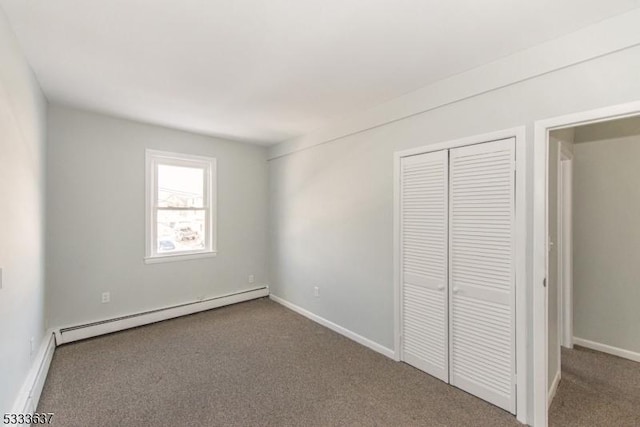 unfurnished bedroom with a baseboard radiator, a closet, and carpet