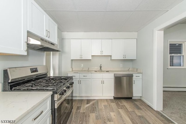 kitchen with sink, white cabinetry, a baseboard heating unit, and appliances with stainless steel finishes