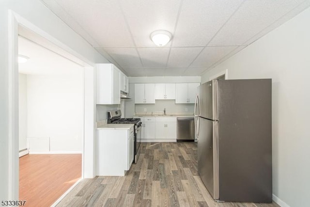 kitchen with white cabinets, sink, stainless steel appliances, a paneled ceiling, and dark hardwood / wood-style floors