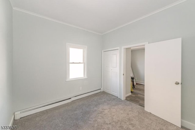 unfurnished bedroom featuring baseboard heating, light colored carpet, a closet, and crown molding