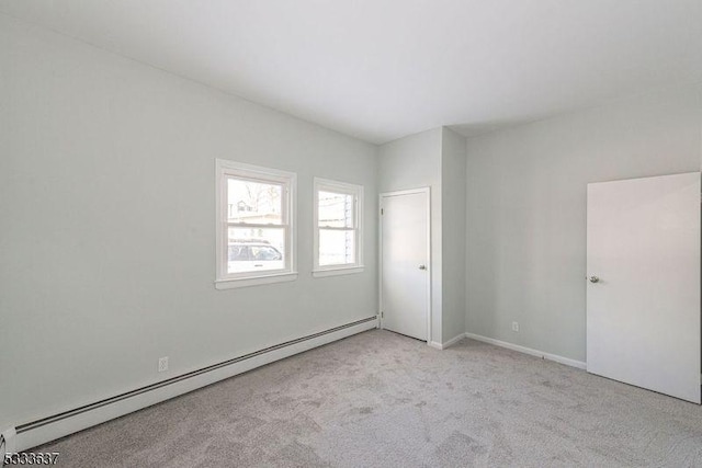 carpeted empty room featuring baseboard heating