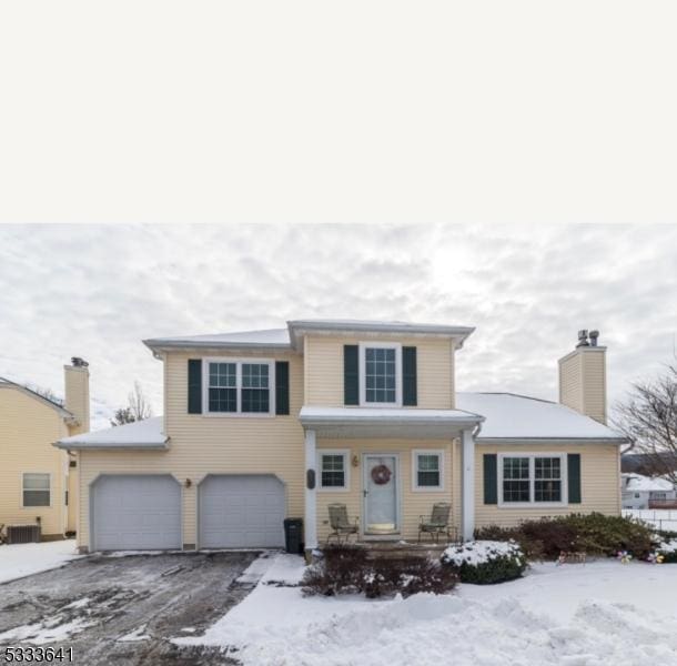 view of front property featuring a garage and central AC unit