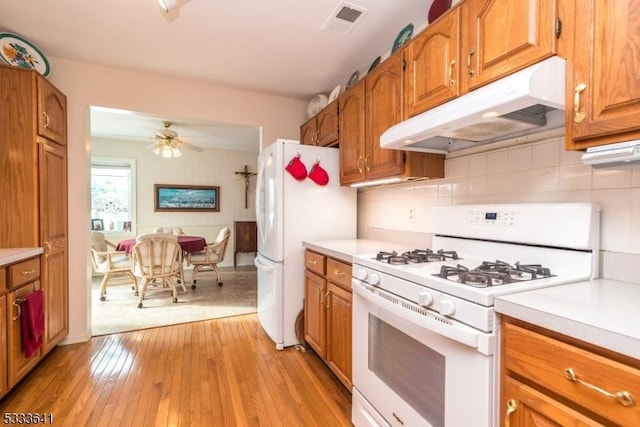 kitchen with tasteful backsplash, white appliances, ceiling fan, and light wood-type flooring