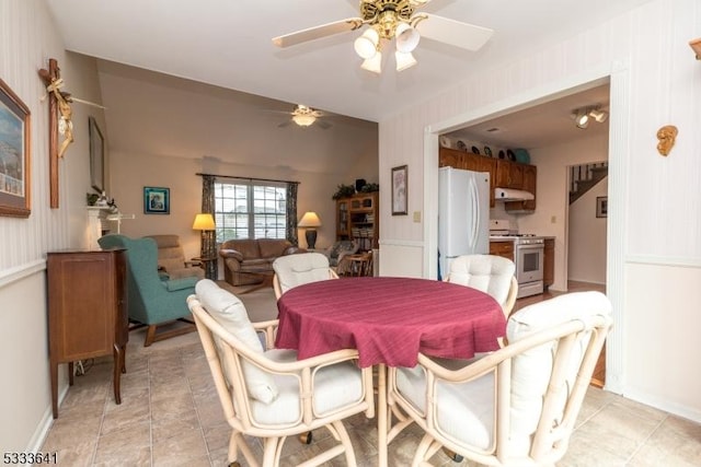 dining room with vaulted ceiling, ceiling fan, and light tile patterned flooring