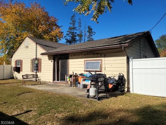 rear view of property featuring a patio area and a lawn