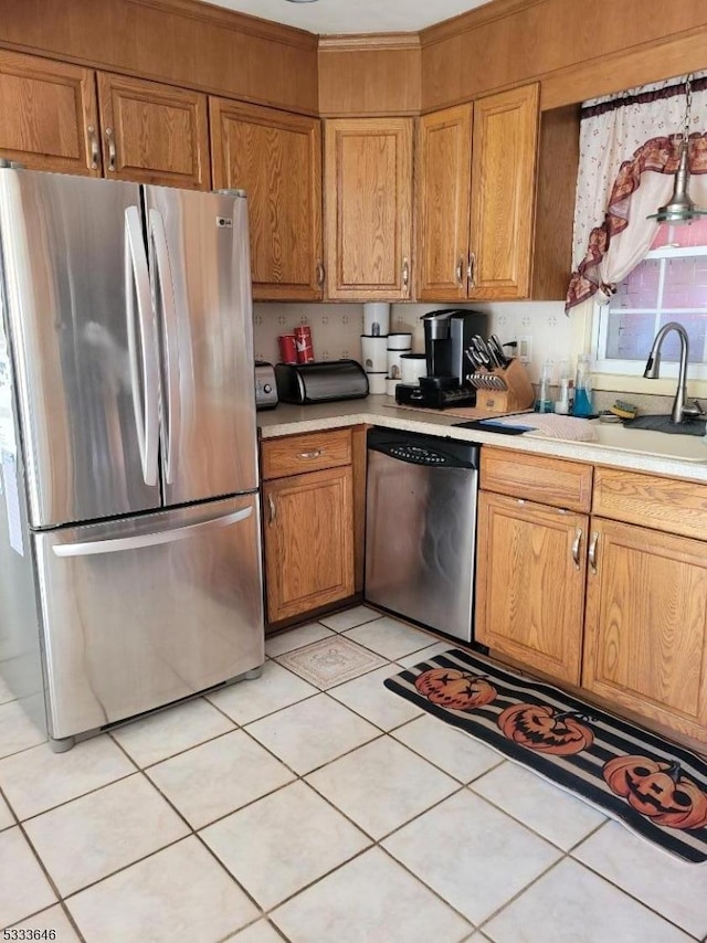 kitchen with stainless steel appliances, sink, and light tile patterned floors