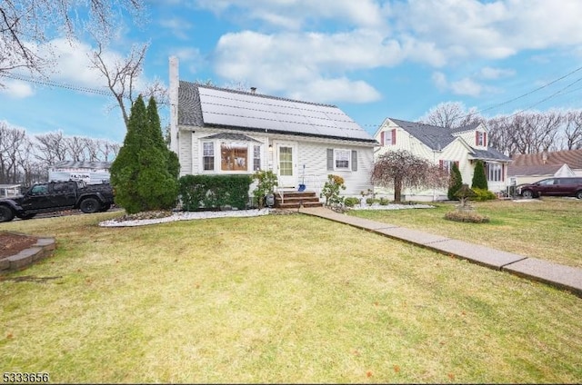 view of front of property with a front yard and solar panels