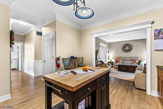 kitchen featuring crown molding, dark brown cabinets, butcher block counters, and light hardwood / wood-style flooring