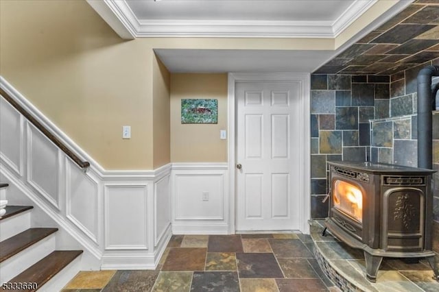 foyer entrance featuring ornamental molding and a wood stove