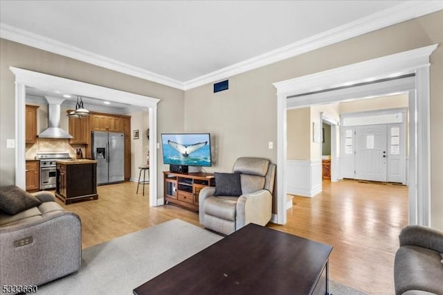 living room with crown molding and light hardwood / wood-style flooring