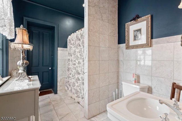 bathroom featuring sink and tile walls