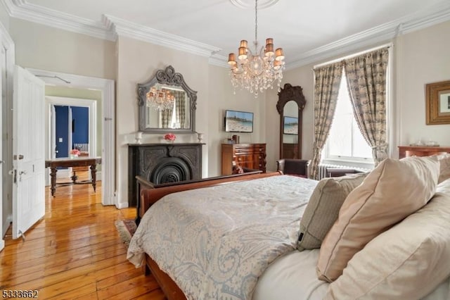 bedroom featuring crown molding, a notable chandelier, and light hardwood / wood-style floors