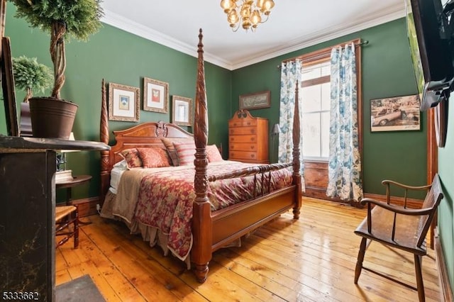 bedroom featuring an inviting chandelier, ornamental molding, and light hardwood / wood-style floors