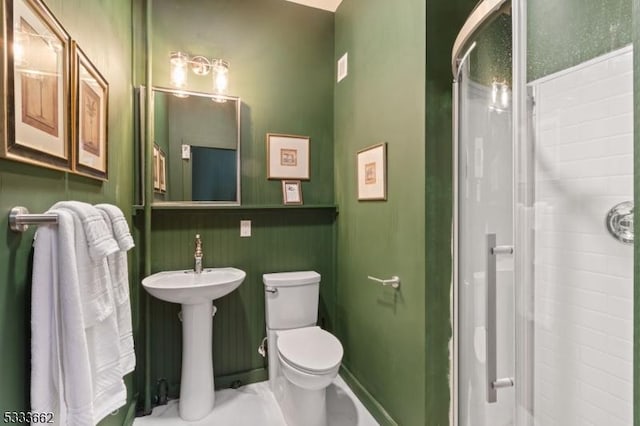 bathroom with toilet, sink, and walk in shower