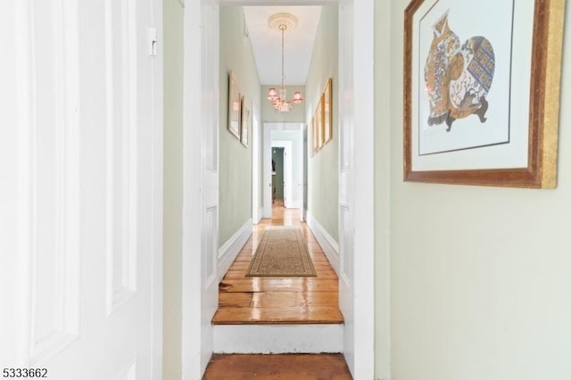 hall with an inviting chandelier