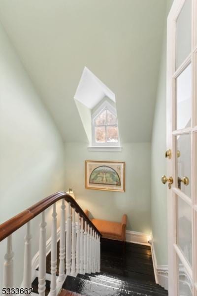 stairway with lofted ceiling and hardwood / wood-style flooring