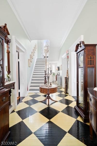 hallway featuring ornamental molding and light hardwood / wood-style floors