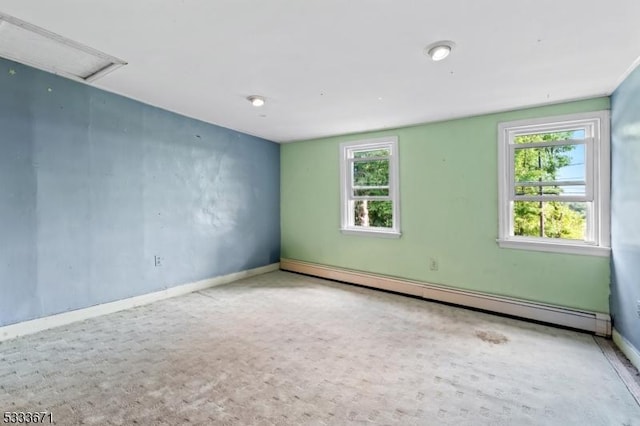 carpeted spare room featuring baseboards, baseboard heating, and a healthy amount of sunlight