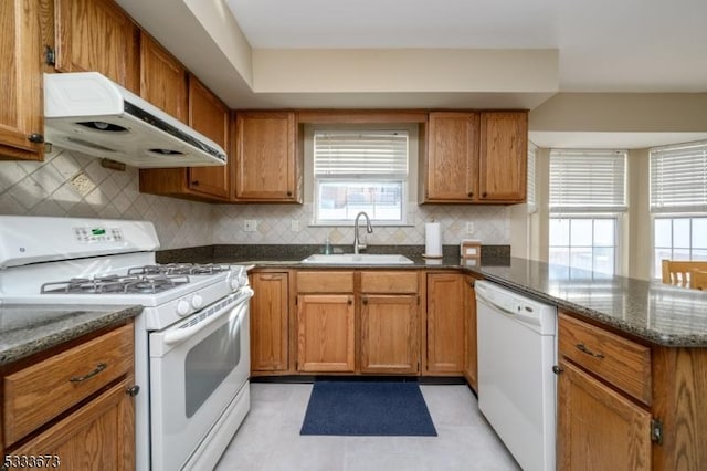 kitchen with white appliances, sink, and backsplash