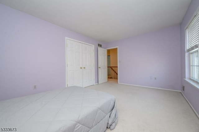 bedroom featuring light colored carpet and a closet