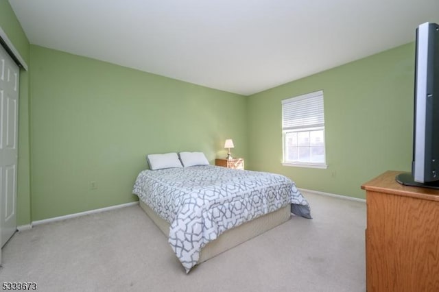 bedroom with light colored carpet and a closet