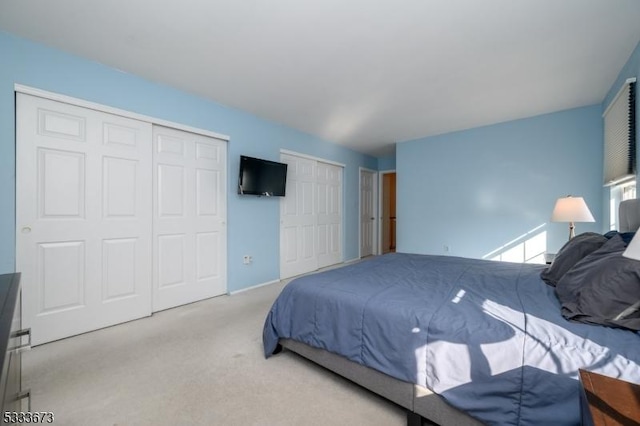 carpeted bedroom featuring multiple closets