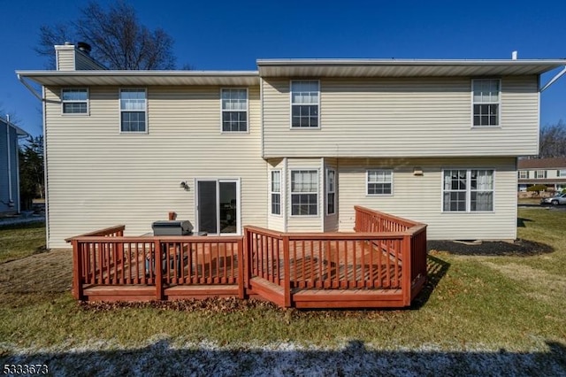 rear view of property featuring a wooden deck and a yard