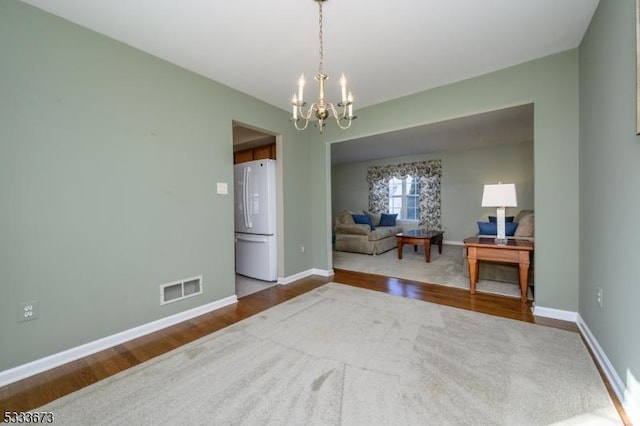 interior space featuring hardwood / wood-style flooring and an inviting chandelier