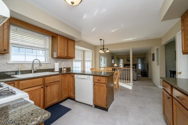 kitchen featuring white appliances, sink, hanging light fixtures, and backsplash