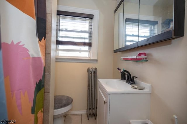 bathroom featuring vanity, toilet, radiator, and plenty of natural light