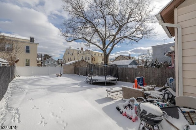 yard covered in snow featuring a trampoline