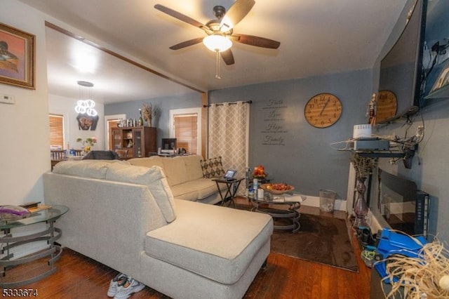 living room featuring a fireplace, ceiling fan with notable chandelier, and dark hardwood / wood-style flooring