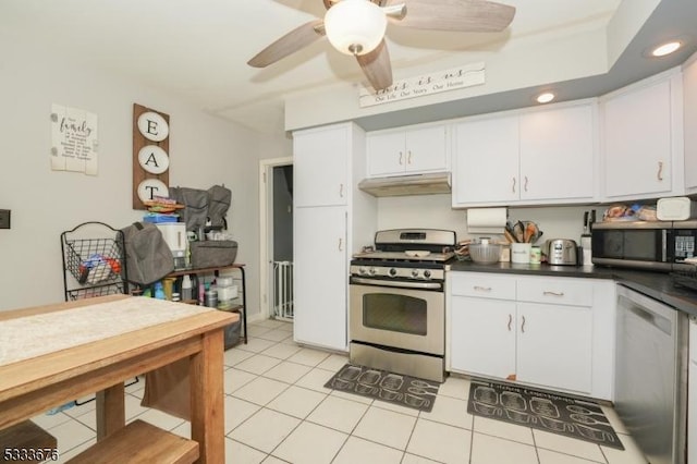 kitchen featuring ceiling fan, stainless steel appliances, white cabinets, under cabinet range hood, and dark countertops