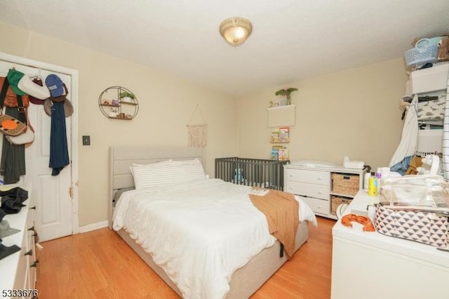 bedroom featuring light wood-style floors and baseboards