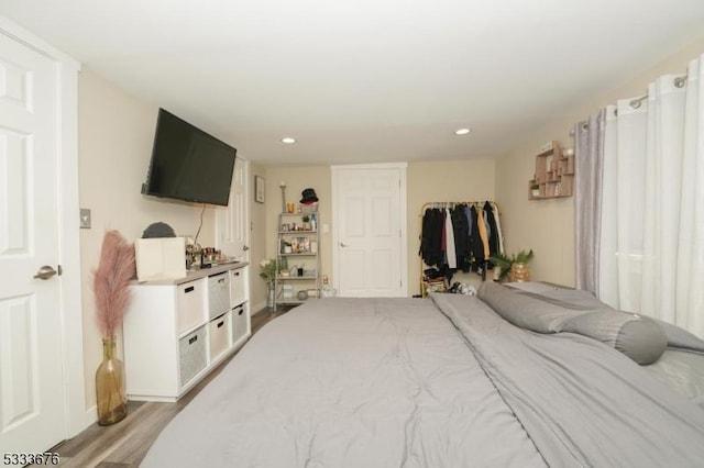 bedroom with light wood-style flooring, recessed lighting, and a closet