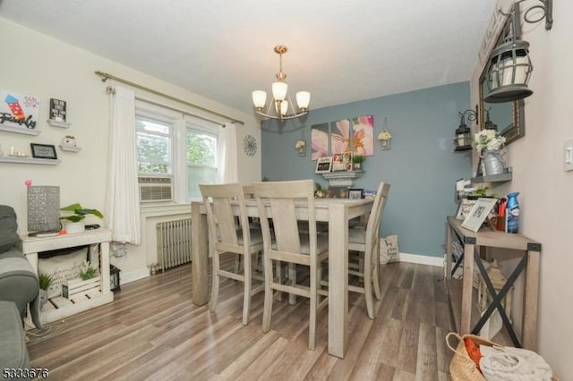 dining room featuring radiator, baseboards, and wood finished floors