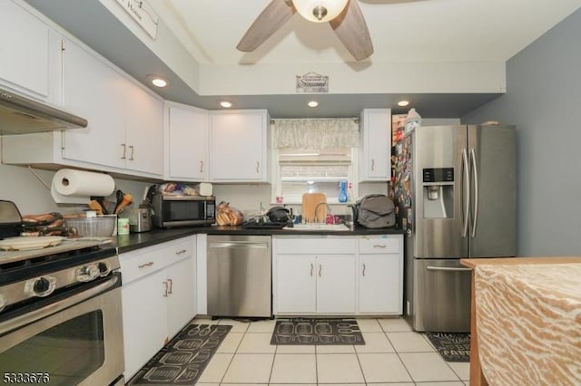 kitchen featuring ceiling fan, light tile patterned floors, appliances with stainless steel finishes, white cabinetry, and a sink